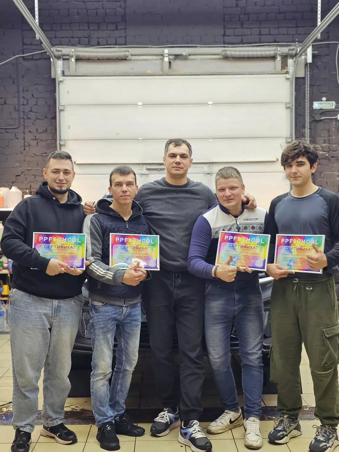 Иван Чеботарев показывает ученику PPF School работу с пленкой на кузовной детали